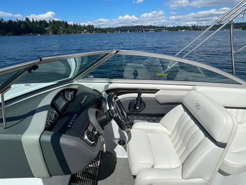 Slide: The Image of Cobalt A25 boat interior with steering wheel, white seats, and scenic lake view. - 15