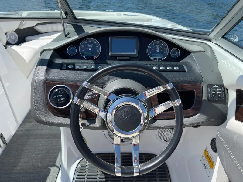 Slide: The Image of Steering wheel and dashboard of a 2011 Cobalt A25 boat, featuring modern controls. - 16