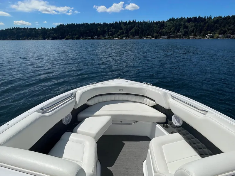 Slide: The Image of 2011 Cobalt A25 boat with white seating on a calm lake under a blue sky. - 18