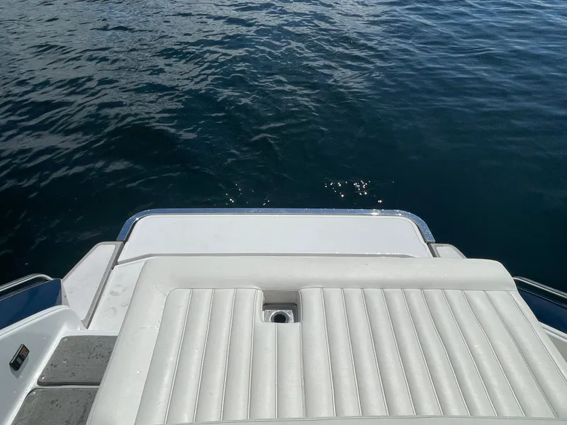Slide: The Image of Rear view of 2011 Cobalt A25 boat with white seating and calm water. - 21