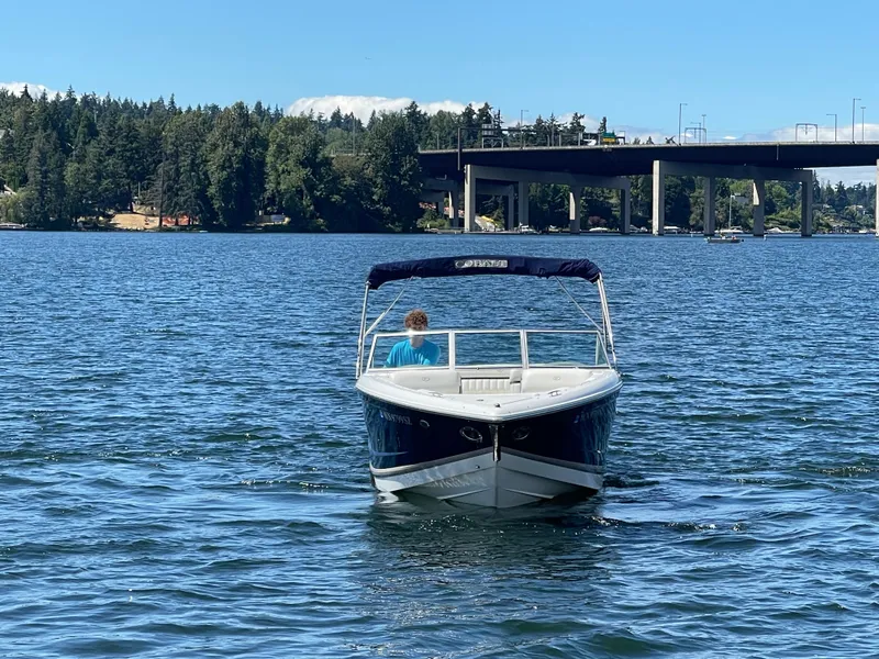 Slide: The Image of 2011 Cobalt A25 boat on a lake with a bridge and forested background. - 3