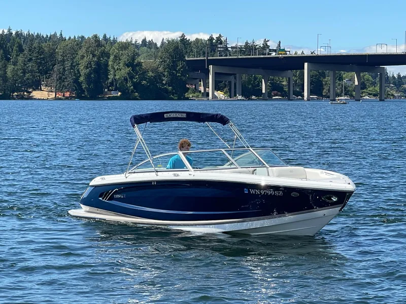 Slide: The Image of 2011 Cobalt A25 boat cruising on a scenic lake with a bridge in the background. - 4