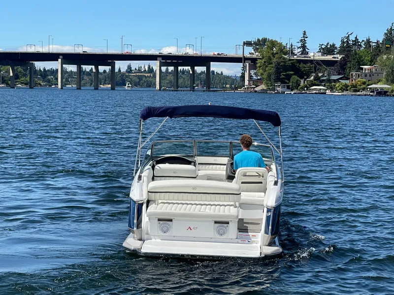 Slide: The Image of 2011 Cobalt A25 boat cruising on a lake near a bridge. - 7