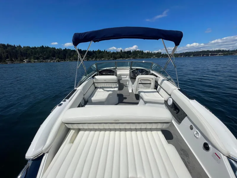 Slide: The Image of 2011 Cobalt A25 boat with white seating, blue canopy, on a serene lake. - 9