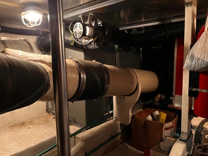 Slide: The Image of Engine room of 1990 Sea Ray Sedan Bridge 500 with visible pipes and equipment. - 36