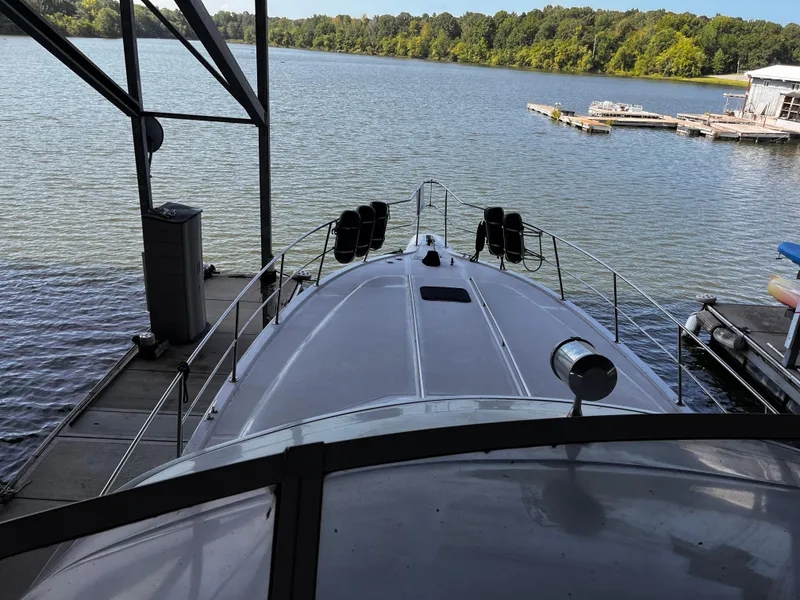 Slide: The Image of 1990 Sea Ray Sedan Bridge 500 docked at a serene lakeside marina. - 39