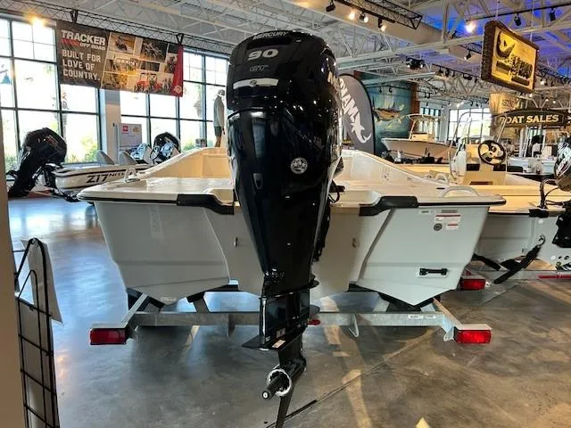Slide: The Image of 2023 Mako Pro Skiff 19 CC boat with outboard motor in showroom. - 2
