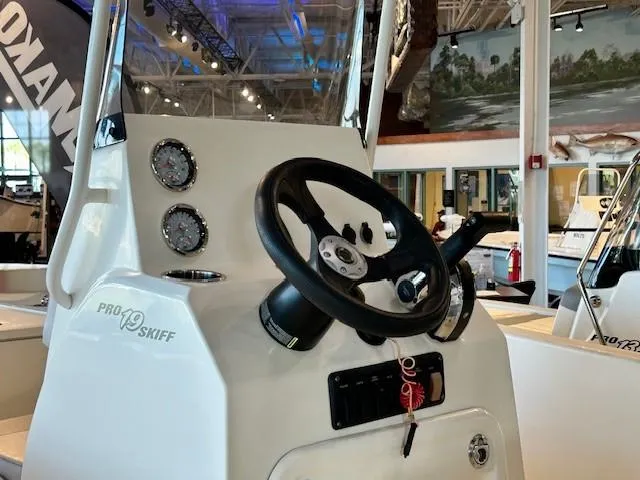 Slide: The Image of 2023 Mako Pro Skiff 19 CC boat console with steering wheel and gauges. - 3