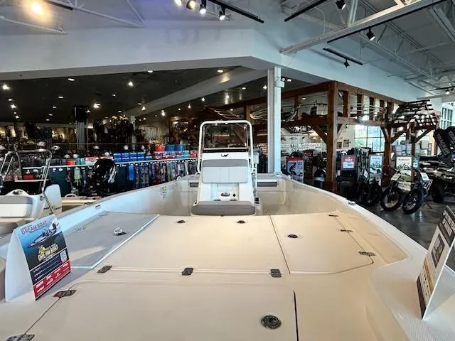 Slide: The Image of 2023 Mako Pro Skiff 19 CC displayed in a showroom with various equipment. - 4