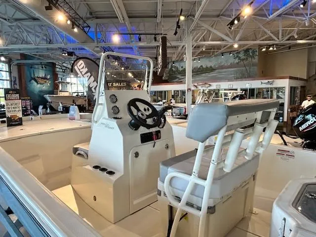 Slide: The Image of 2023 Mako Pro Skiff 19 CC boat interior with steering console and seating in showroom. - 5