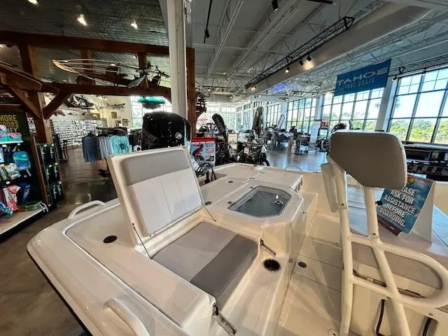 Slide: The Image of 2023 Mako Pro Skiff 19 CC boat displayed in a showroom setting. - 7