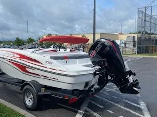 Slide: The Image of 2024 Tahoe T18 boat with outboard motor on trailer, parked outdoors. - 9