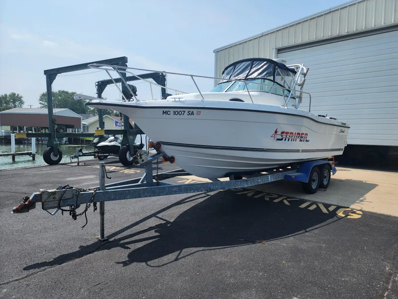Slide: The Image of 2000 Seaswirl Striper 2600 Walkaround I/O boat on trailer near marina. - 1