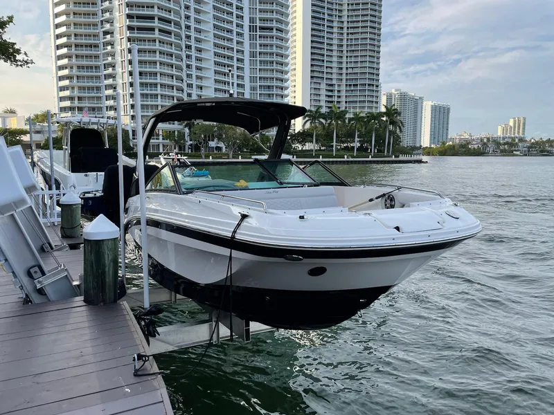 The Image of 2022 Sea Ray SDX 250 boat docked by waterfront skyscrapers. - 0
