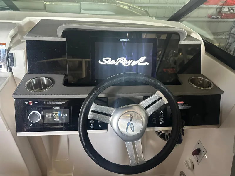Slide: The Image of 2022 Sea Ray SDX 250 dashboard with steering wheel and digital display. - 2