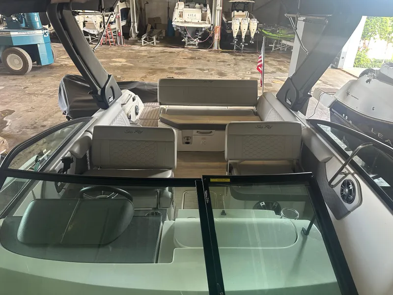 Slide: The Image of 2022 Sea Ray SDX 250 boat interior with seating and windshield in a storage facility. - 3