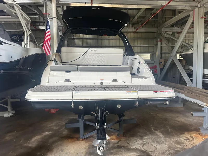 Slide: The Image of 2022 Sea Ray SDX 250 boat in storage, rear view with American flag. - 8