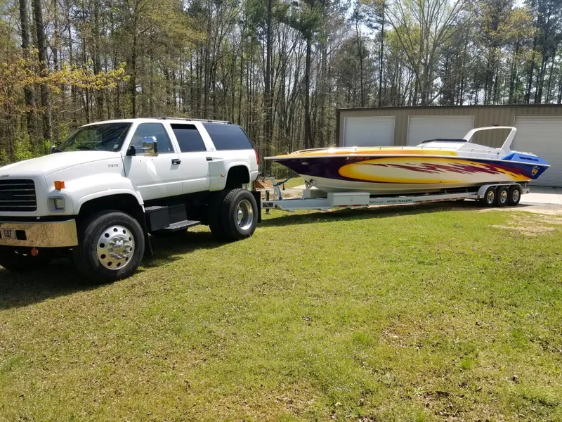 Slide: The Image of White truck towing 1990 Fountain 42 Lightning speedboat on grassy area. - 13