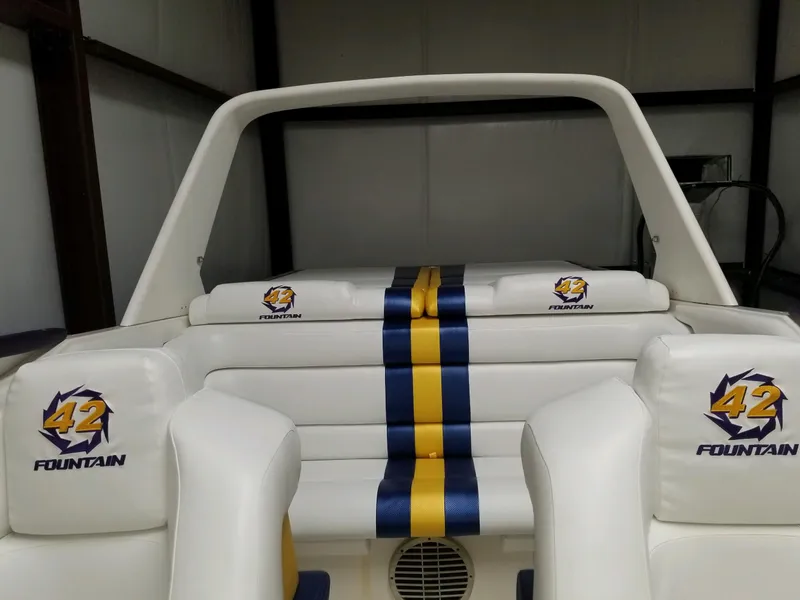 Slide: The Image of 1990 Fountain 42 Lightning boat interior with white seats and blue-yellow stripes. - 24
