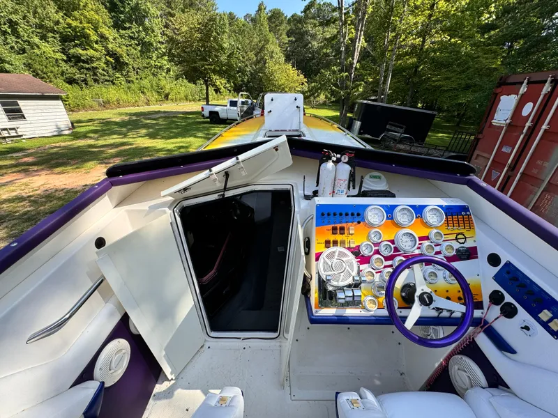 Slide: The Image of 1990 Fountain 42 Lightning boat cockpit with colorful dashboard and steering wheel. - 25