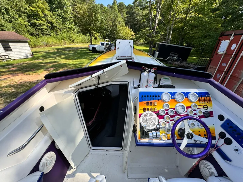 Slide: The Image of 1990 Fountain 42 Lightning boat cockpit with colorful dashboard and steering wheel. - 26