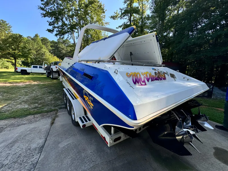 Slide: The Image of 1990 Fountain 42 Lightning speedboat on trailer, vibrant blue and white design, parked outdoors. - 3