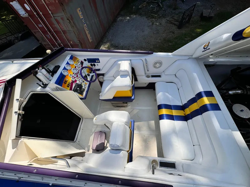 Slide: The Image of 1990 Fountain 42 Lightning boat interior with white seating and blue-yellow accents. - 47