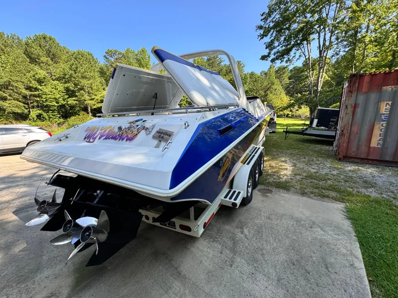 Slide: The Image of 1990 Fountain 42 Lightning speedboat with open engine hatch, parked outdoors. - 5