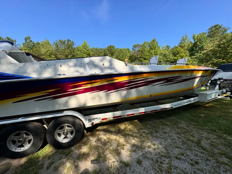 Slide: The Image of 1990 Fountain 42 Lightning speedboat on trailer, vibrant graphics, parked outdoors. - 7