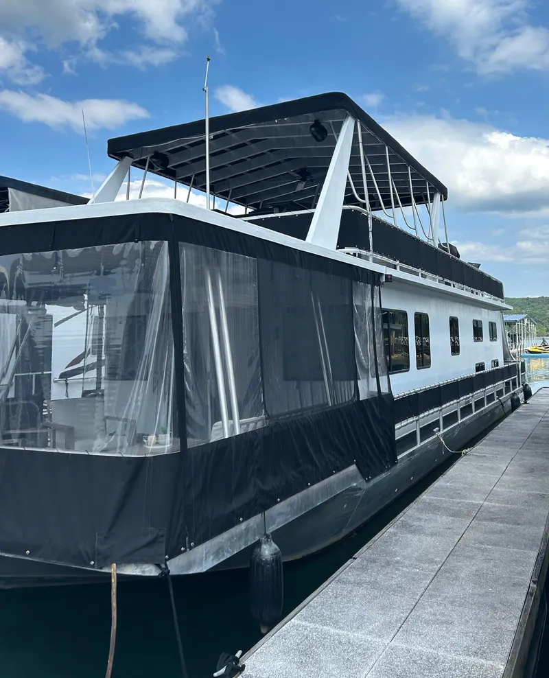 Slide: The Image of 2004 Majestic Houseboat docked under a clear blue sky. - 10