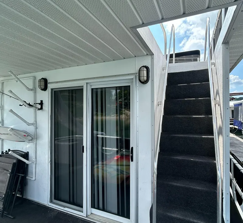 Slide: The Image of 2004 Majestic houseboat with sliding glass doors and carpeted stairs. - 19