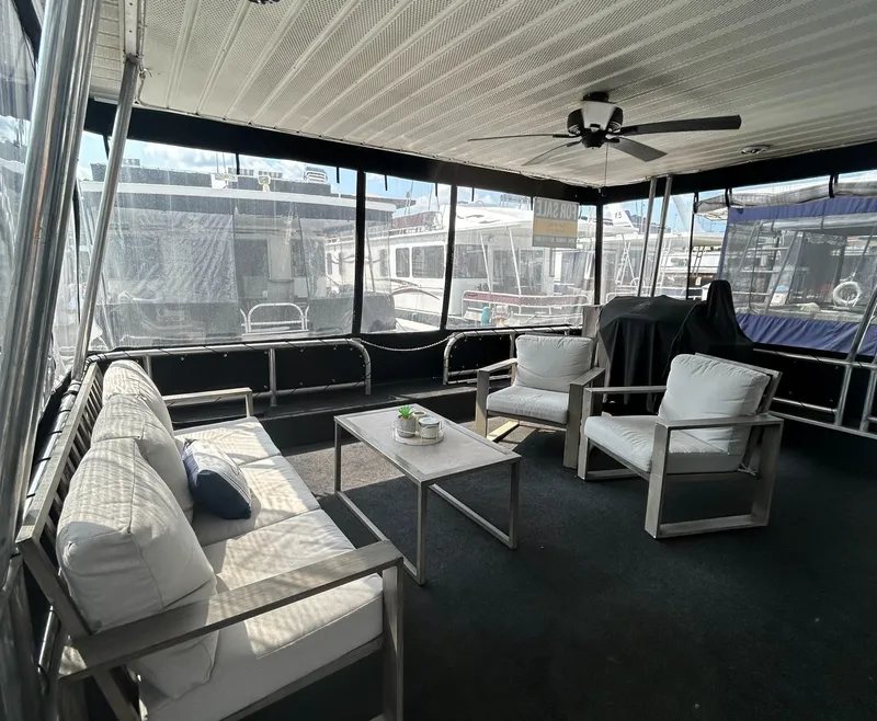 Slide: The Image of Spacious 2004 Majestic houseboat interior with modern seating and ceiling fan. - 21