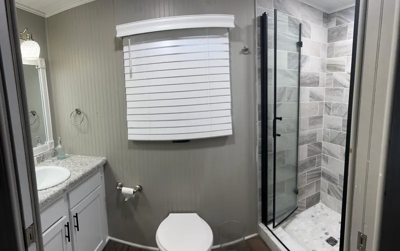 Slide: The Image of Modern bathroom in a 2004 Majestic houseboat with shower, toilet, and vanity. - 25