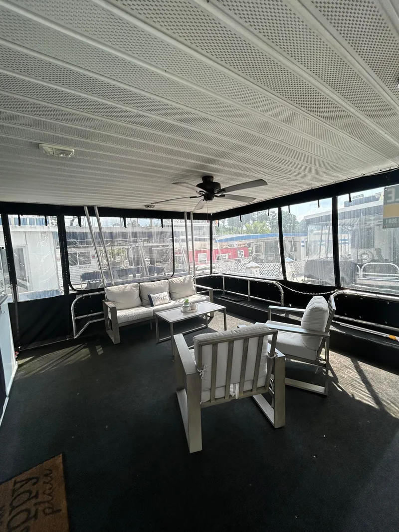 Slide: The Image of Spacious 2004 Majestic houseboat interior with comfortable seating and ceiling fan. - 3
