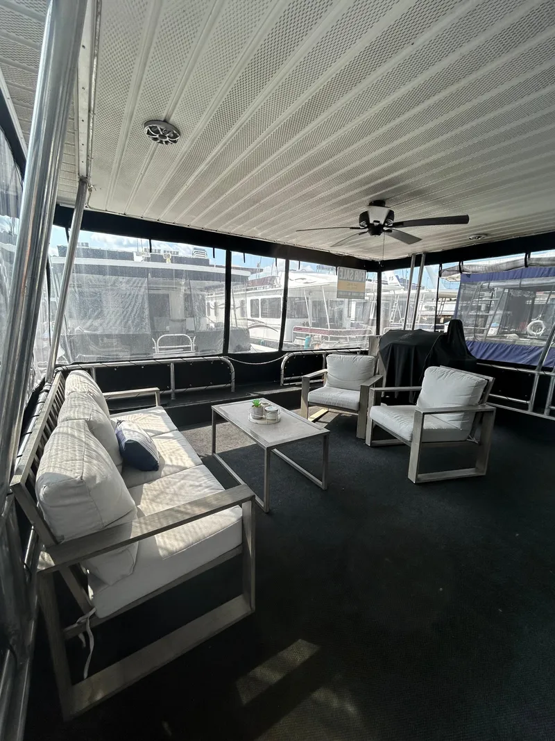 Slide: The Image of Spacious 2004 Majestic houseboat interior with modern seating and ceiling fan. - 4