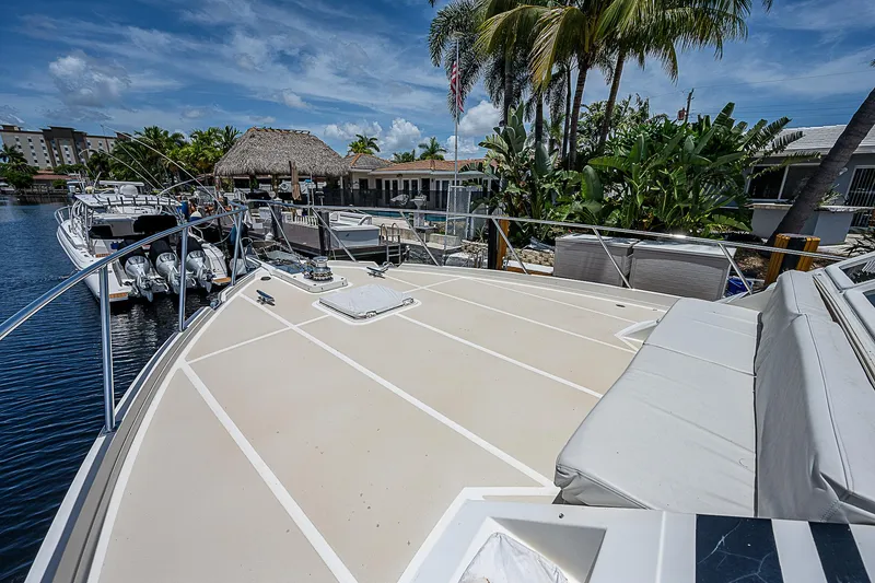 Slide: The Image of Offshore Yachts 62 Pilot House 2000 docked, spacious deck, tropical marina setting. - 14