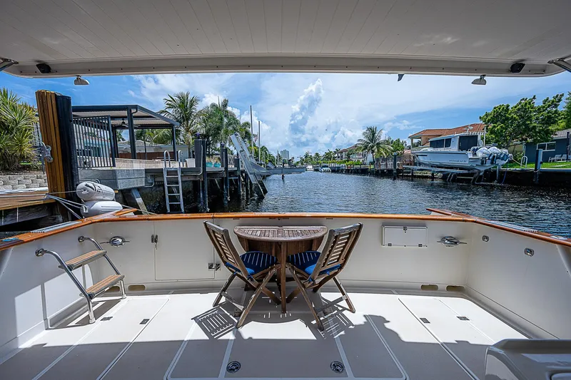 Slide: The Image of 2000 Offshore Yachts 62 Pilot House, spacious deck view, canal backdrop, sunny day. - 17