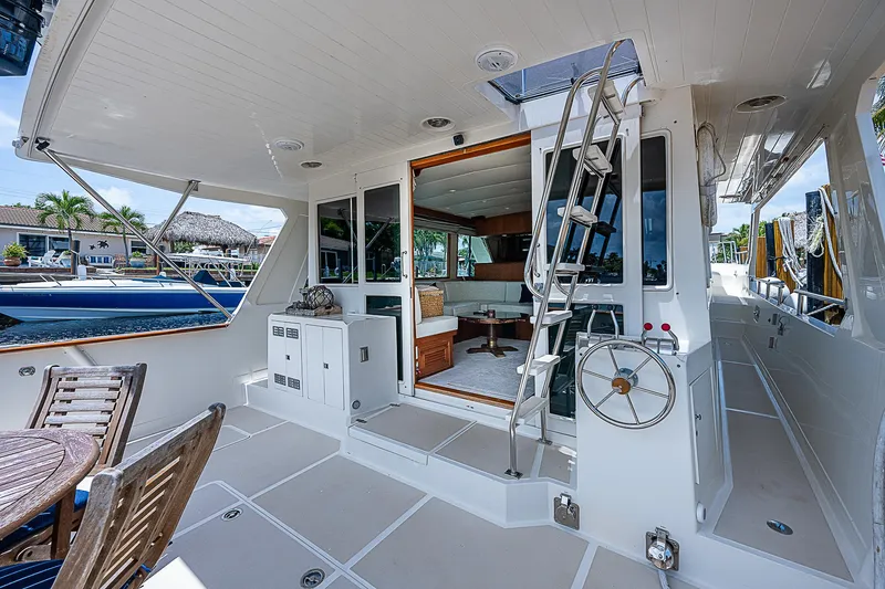 Slide: The Image of 2000 Offshore Yachts 62 Pilot House, spacious deck with seating and helm, luxury yacht interior. - 19