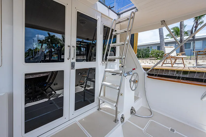 Slide: The Image of Offshore Yachts 62 Pilot House 2000, featuring a sleek deck with ladder and glass doors. - 20