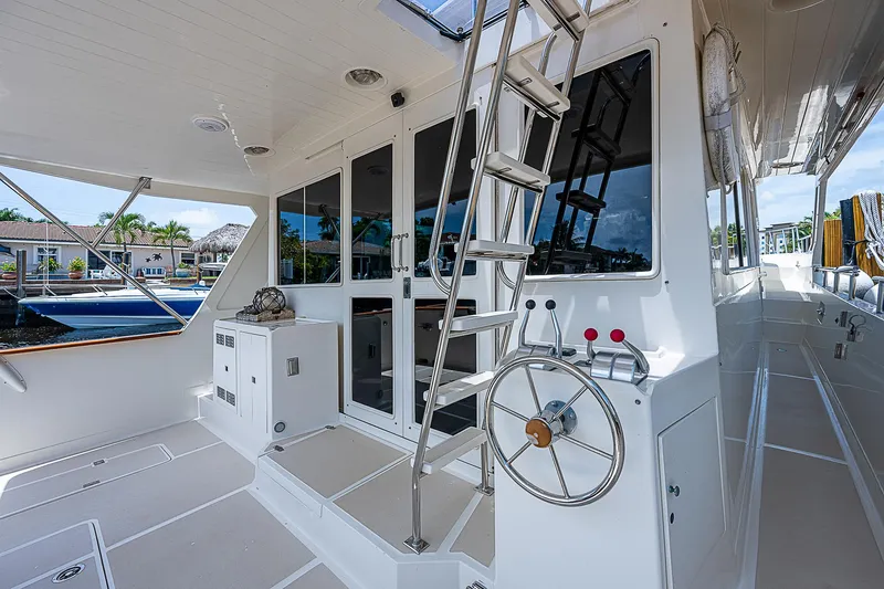 Slide: The Image of 2000 Offshore Yachts 62 Pilot House deck with steering wheel and ladder. - 21