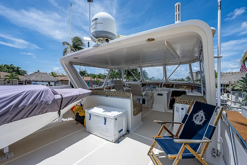 Slide: The Image of 2000 Offshore Yachts 62 Pilot House deck with seating and equipment under clear blue sky. - 30