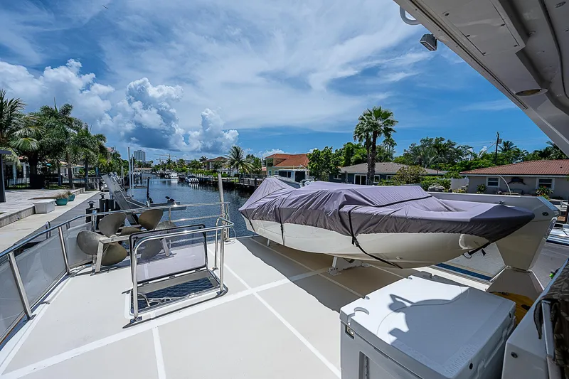 Slide: The Image of Offshore Yachts 62 Pilot House 2000 on deck, docked by a scenic waterfront. - 33
