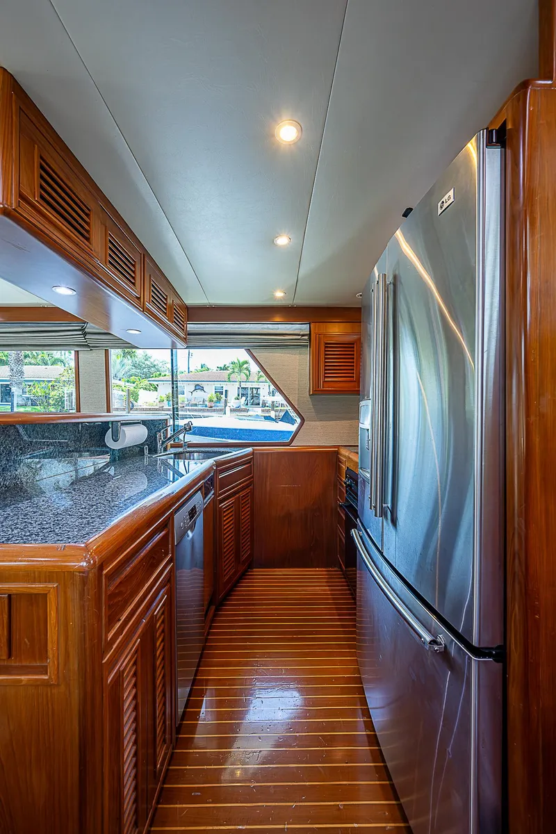 Slide: The Image of Luxurious kitchen interior of 2000 Offshore Yachts 62 Pilot House with wood cabinetry and stainless appliances. - 43