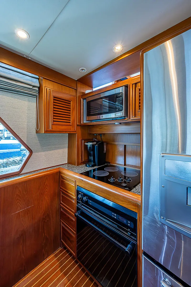 Slide: The Image of Luxurious kitchen in 2000 Offshore Yachts 62 Pilot House with modern appliances and wood cabinetry. - 44