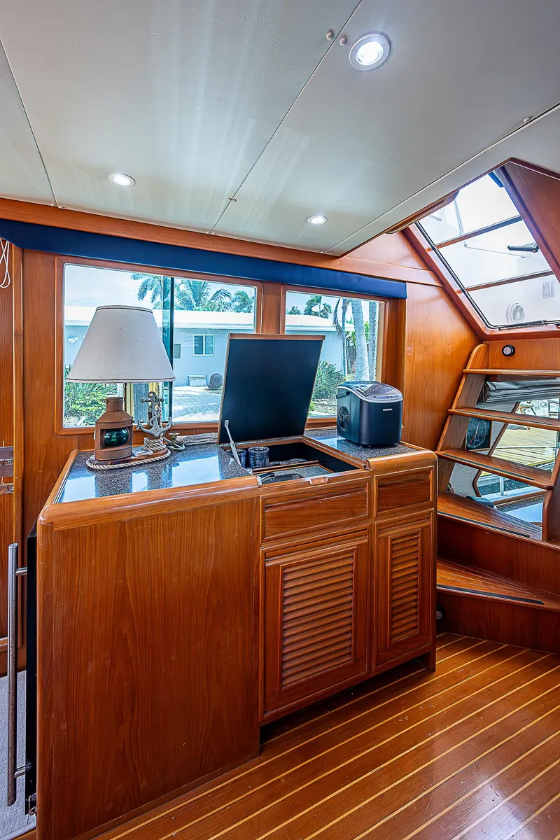Slide: The Image of Interior of 2000 Offshore Yachts 62 Pilot House with wood cabinetry and large windows. - 45