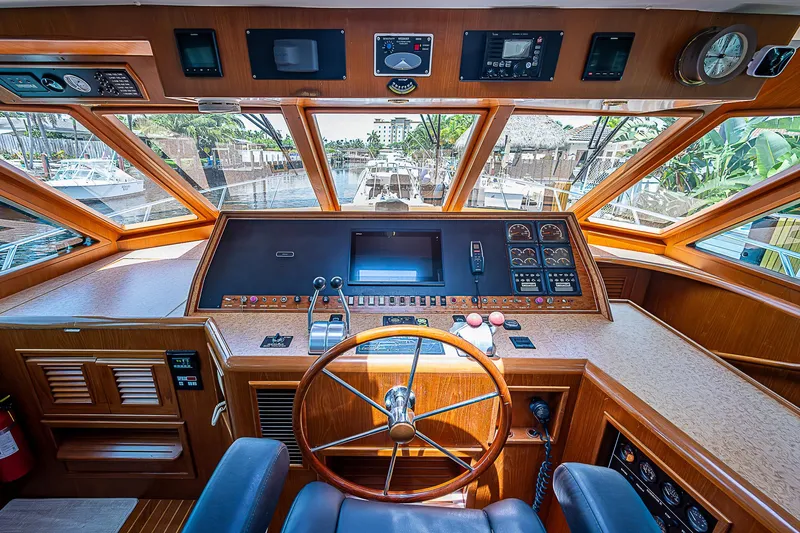 Slide: The Image of Interior of 2000 Offshore Yachts 62 Pilot House with wooden helm and navigation instruments. - 46