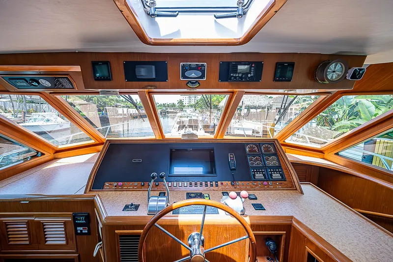 Slide: The Image of Interior view of 2000 Offshore Yachts 62 Pilot House helm with navigation controls. - 48