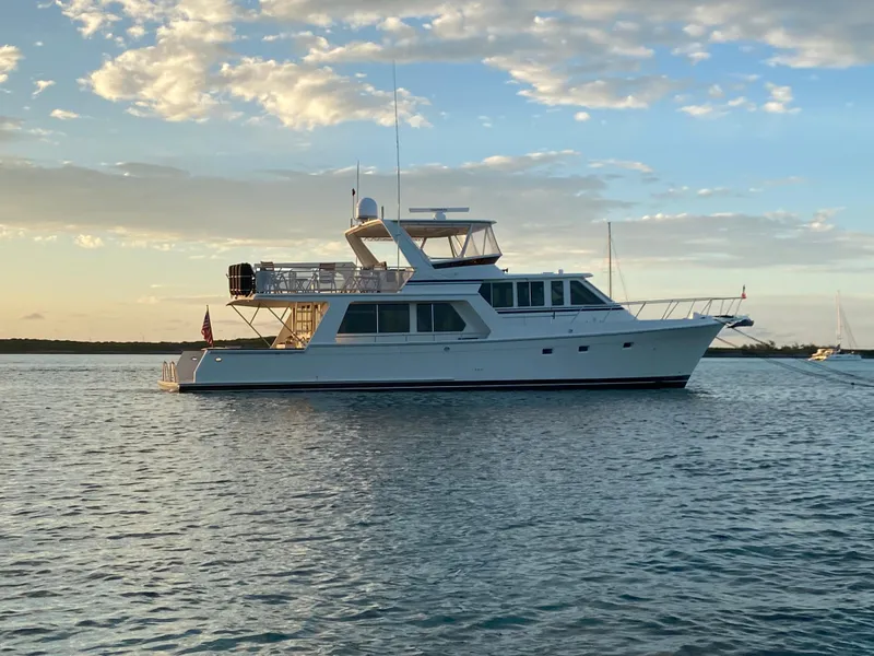 Slide: The Image of 2000 Offshore Yachts 62 Pilot House on calm water at sunset. - 9