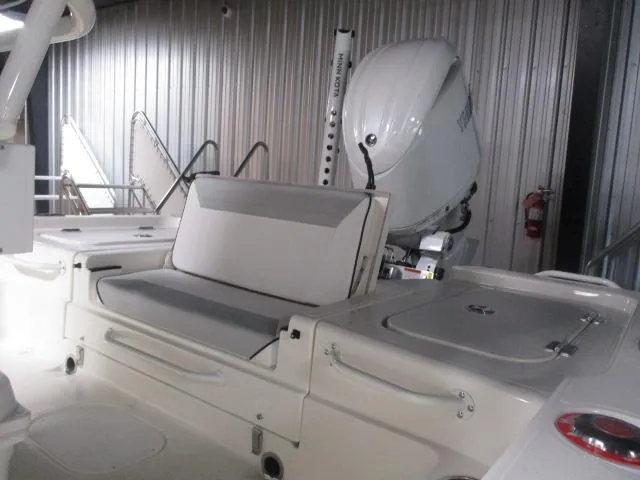 Slide: The Image of 2025 Skeeter SX221 boat interior with seating and outboard motor in a storage facility. - 8