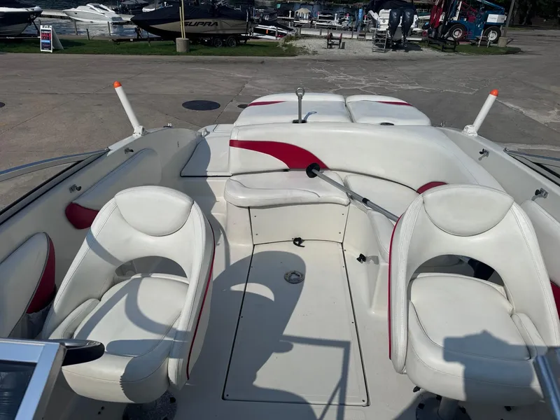 Slide: The Image of 2006 Sugar Sand Oasis boat interior with white and red seating at a marina. - 13